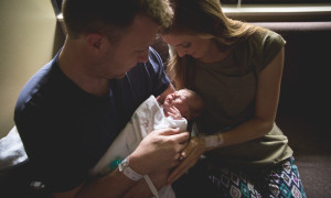 father and mother admire newborn