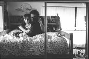 self portrait in mirror mother and son sitting on bed
