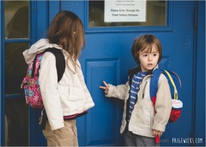 brother and sister waiting for school to open wearing backpacks