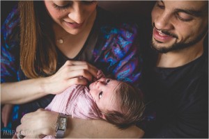 newborn girl with parents smiling