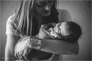 new mother smiles at infant black and white photography