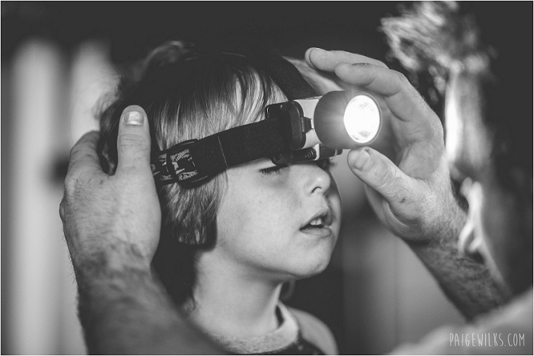 little boy trying on headlamp with fathers hands