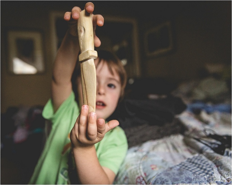 little boy holding hand carved wood knife
