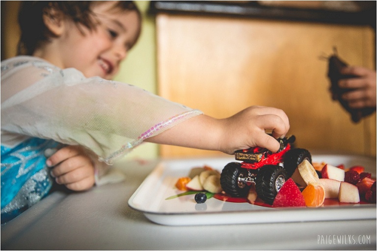 boy in princess dress smashing food with truck