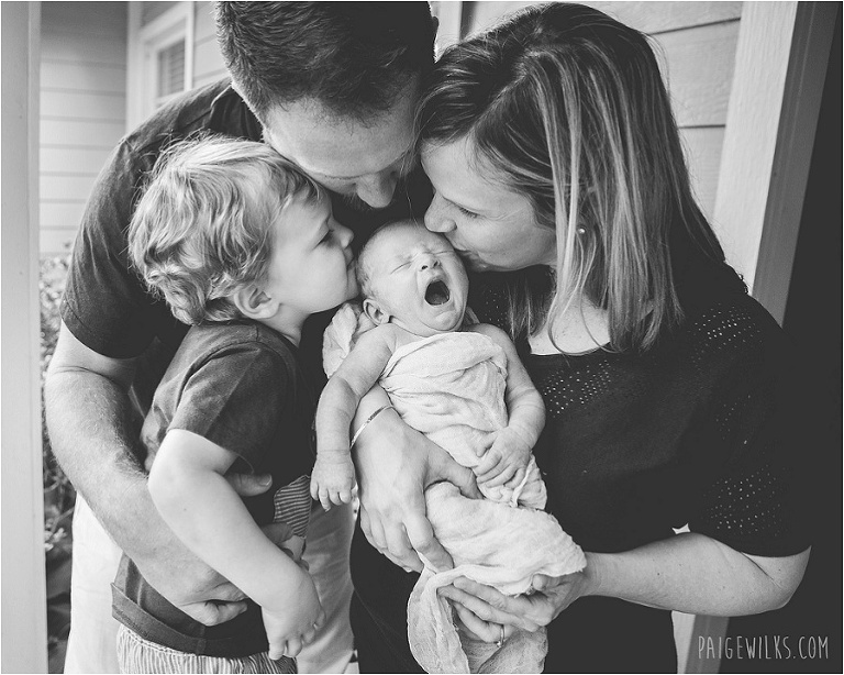 family photo new baby yawns kissing 