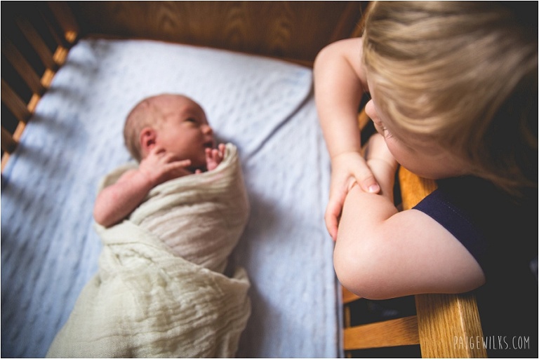 big brother watches over baby in cradle 
